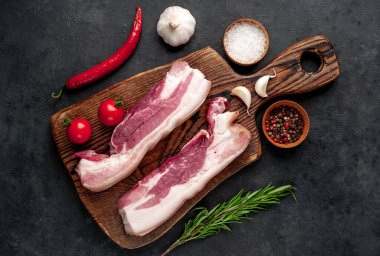 Metnin için fotokopi alanı olan taştan bir arka planda kesilmiş baharatlı çiğ domuz göğsü.