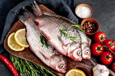 Limonlu ve kekikli Crucian sazan balığı taştan bir arka planda tahta üzerinde. Nehir balığı .