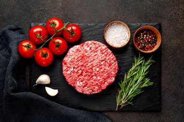 Biberiyeli çiğ hamburger köftesi ve arka planda baharatlar