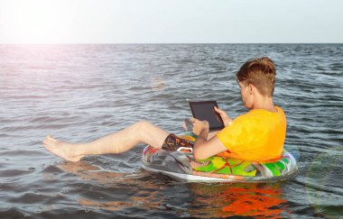 Suda şişme yüzük tabletli bir adam.