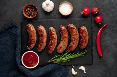 Bir taş zemin üzerinde baharatlı ızgara sosisler ve metin için kopyalama alanı.