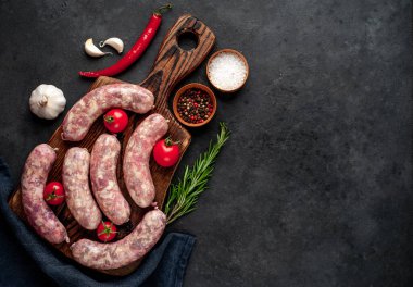 Metnin için kopyalama alanı olan taştan bir arka planda kesilmiş baharatlı çiğ sosisler.