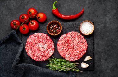 Biberiyeli hamburgerler ve arka planda baharatlar.
