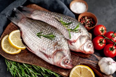 Limonlu ve kekikli Crucian sazan balığı taştan bir arka planda tahta üzerinde. Nehir balığı .