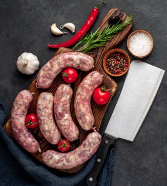 Metnin için kopyalama alanı olan taştan bir arka planda kesilmiş baharatlı çiğ sosisler.