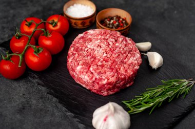 Biberiyeli çiğ hamburger köftesi ve arka planda baharatlar