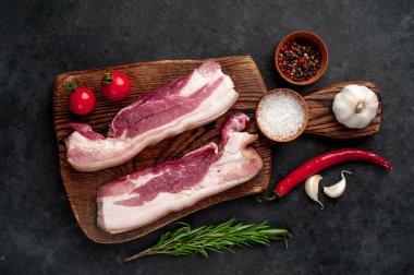 Metnin için fotokopi alanı olan taştan bir arka planda kesilmiş baharatlı çiğ domuz göğsü.