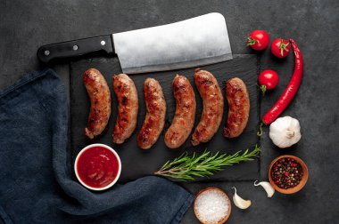 Bir taş zemin üzerinde baharatlı ızgara sosisler ve metin için kopyalama alanı.