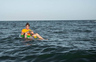 Suda şişme yüzük tabletli bir adam.