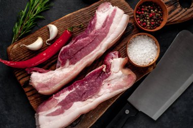 Metnin için fotokopi alanı olan taştan bir arka planda kesilmiş baharatlı çiğ domuz göğsü.