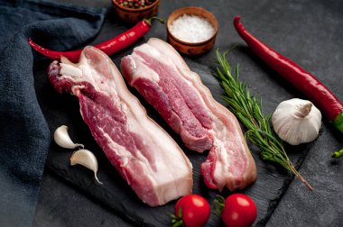 Metnin için fotokopi alanı olan taştan bir arka planda kesilmiş baharatlı çiğ domuz göğsü.