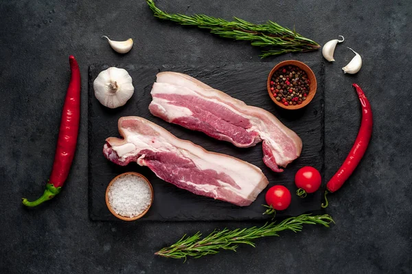 Metnin için fotokopi alanı olan taştan bir arka planda kesilmiş baharatlı çiğ domuz göğsü.