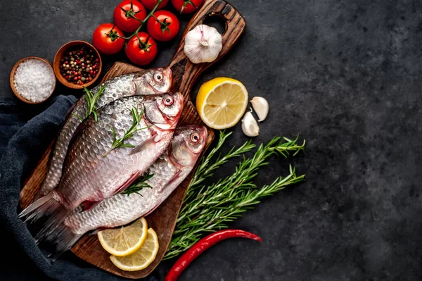 Limonlu ve kekikli Crucian sazan balığı taştan bir arka planda tahta üzerinde. Nehir balığı .