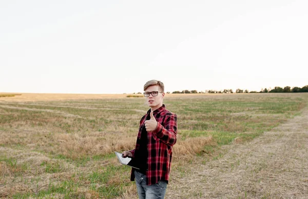 Tarlada gün batımında tabletli çiftçi, tarım yönetimi kavramı