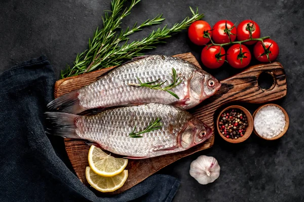 Limonlu ve kekikli Crucian sazan balığı taştan bir arka planda tahta üzerinde. Nehir balığı .