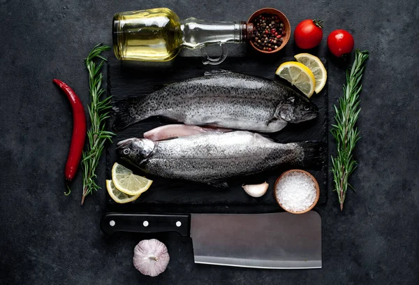 Taş zeminde baharat ve malzemelerle çiğ balık alabalığı.