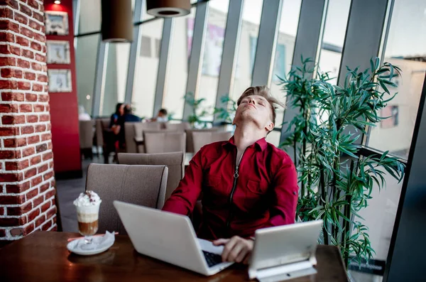 Een Man Zit Aan Een Tafel Werkt Een Laptop — Stockfoto