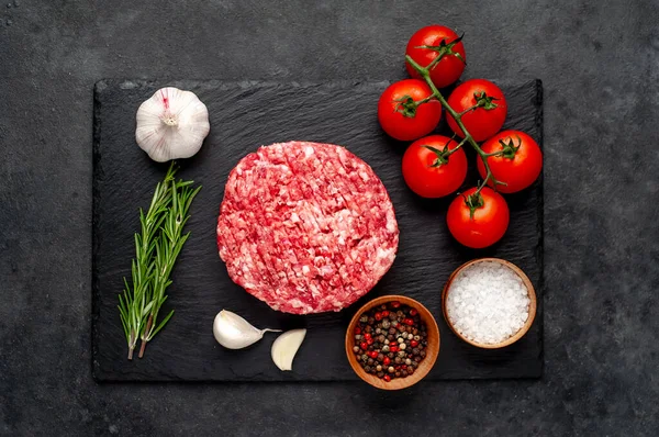 Biberiyeli çiğ hamburger köftesi ve arka planda baharatlar