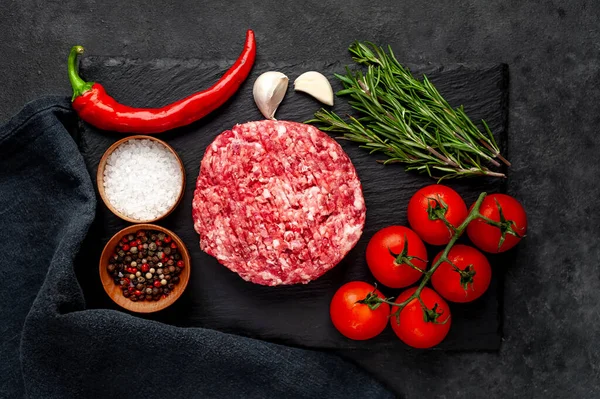 Biberiyeli çiğ hamburger köftesi ve arka planda baharatlar