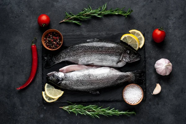 Taş zeminde baharat ve malzemelerle çiğ balık alabalığı.