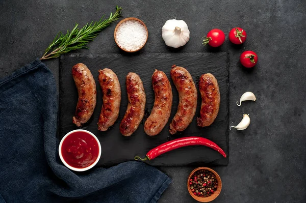Bir taş zemin üzerinde baharatlı ızgara sosisler ve metin için kopyalama alanı.