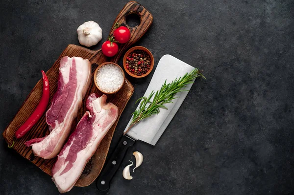 Metnin için fotokopi alanı olan taştan bir arka planda kesilmiş baharatlı çiğ domuz göğsü.