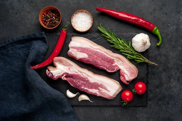 Metnin için fotokopi alanı olan taştan bir arka planda kesilmiş baharatlı çiğ domuz göğsü.