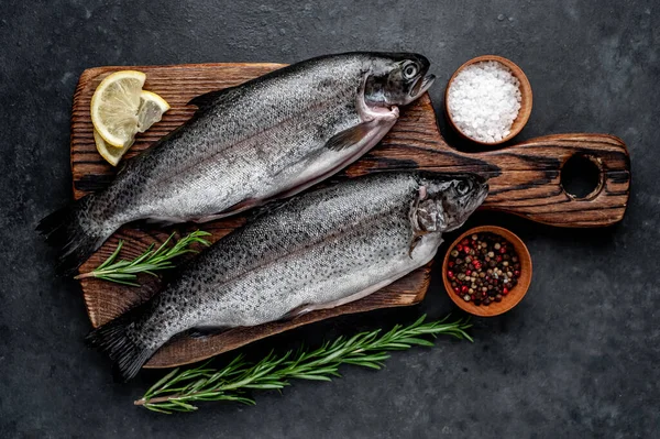 Taş zeminde baharat ve malzemelerle çiğ balık alabalığı.