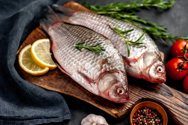 Limonlu ve kekikli Crucian sazan balığı taştan bir arka planda tahta üzerinde. Nehir balığı .