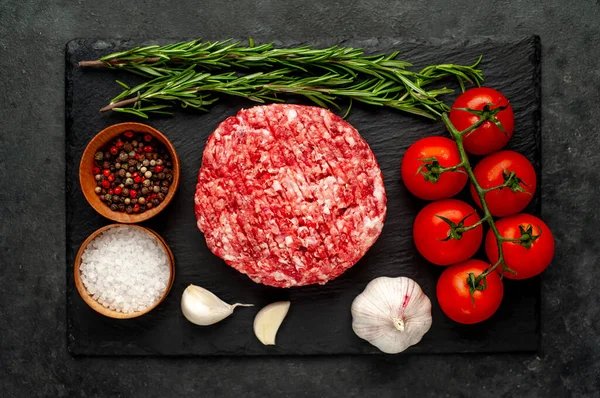 Biberiyeli çiğ hamburger köftesi ve arka planda baharatlar