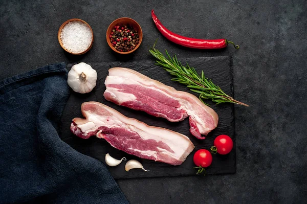 Metnin için fotokopi alanı olan taştan bir arka planda kesilmiş baharatlı çiğ domuz göğsü.