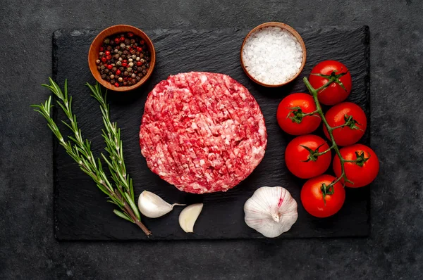 Biberiyeli çiğ hamburger köftesi ve arka planda baharatlar