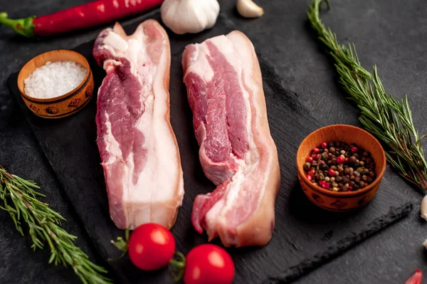 Metnin için fotokopi alanı olan taştan bir arka planda kesilmiş baharatlı çiğ domuz göğsü.