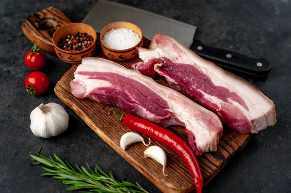 Metnin için fotokopi alanı olan taştan bir arka planda kesilmiş baharatlı çiğ domuz göğsü.