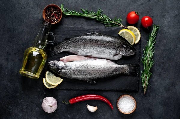 Taş zeminde baharat ve malzemelerle çiğ balık alabalığı.