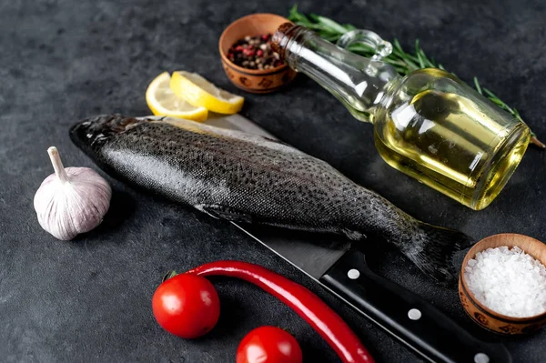 Taş zeminde baharat ve malzemelerle çiğ balık alabalığı.