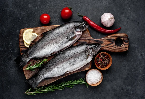 Taş zeminde baharat ve malzemelerle çiğ balık alabalığı.