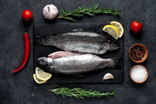 Taş zeminde baharat ve malzemelerle çiğ balık alabalığı.