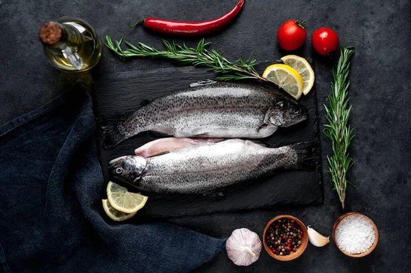 Taş zeminde baharat ve malzemelerle çiğ balık alabalığı.