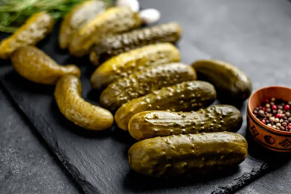 Siyah tahta üzerinde salatalık turşusu.