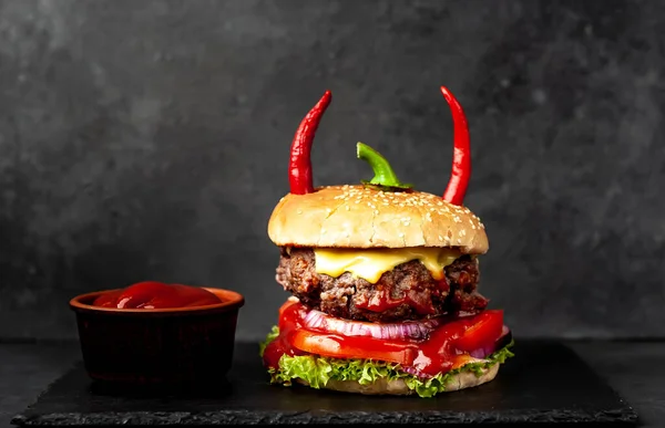 halloween burger with red pepper horns on stone background