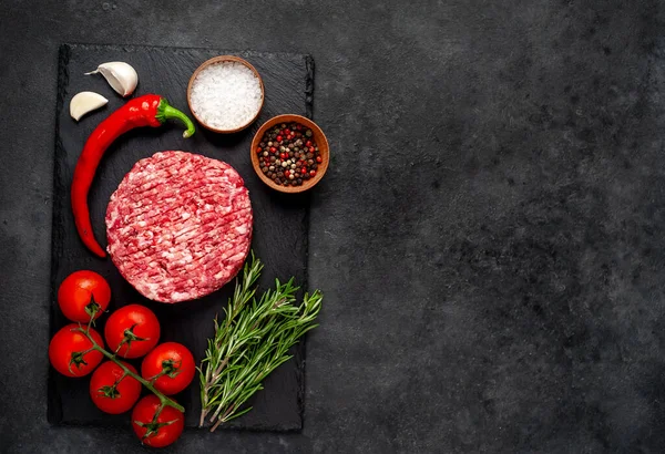 Biberiyeli çiğ hamburger köftesi ve arka planda baharatlar