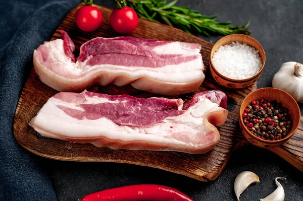 Metnin için fotokopi alanı olan taştan bir arka planda kesilmiş baharatlı çiğ domuz göğsü.