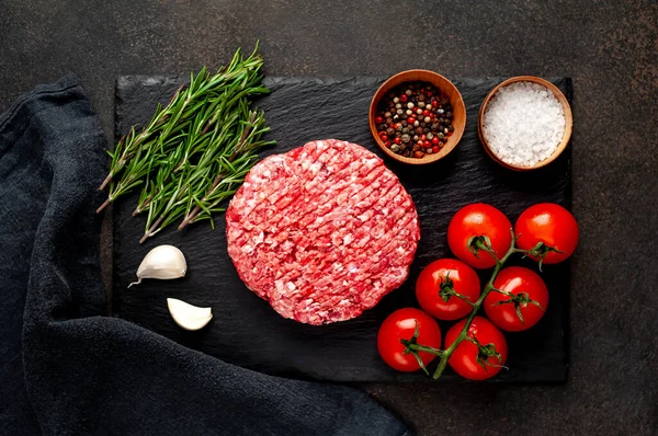 Biberiyeli çiğ hamburger köftesi ve arka planda baharatlar