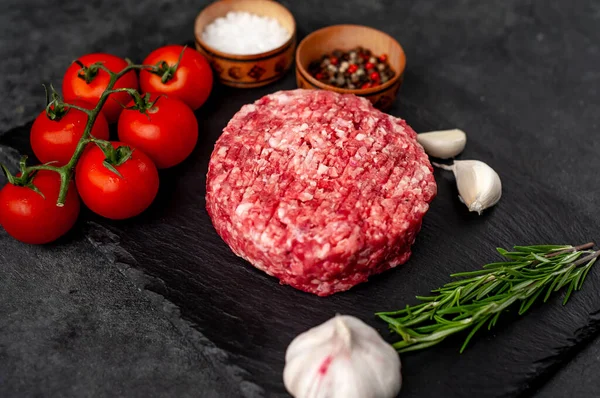 Biberiyeli çiğ hamburger köftesi ve arka planda baharatlar