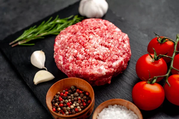 Biberiyeli çiğ hamburger köftesi ve arka planda baharatlar