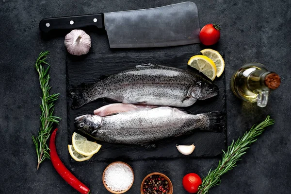 Taş zeminde baharat ve malzemelerle çiğ balık alabalığı.