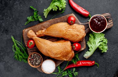 Arka planda baharat olan tütsülenmiş tavuk butları.