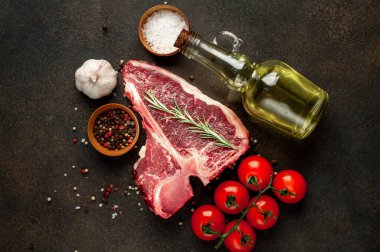 Taştan arka planda et bıçağındaki malzemelerle birlikte çiğ biftek yakın plan görüntüsü.