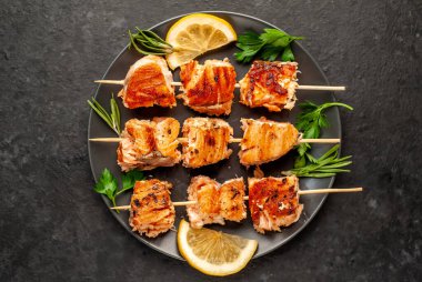 Koyu taş arka planda ızgara somon kebabı.